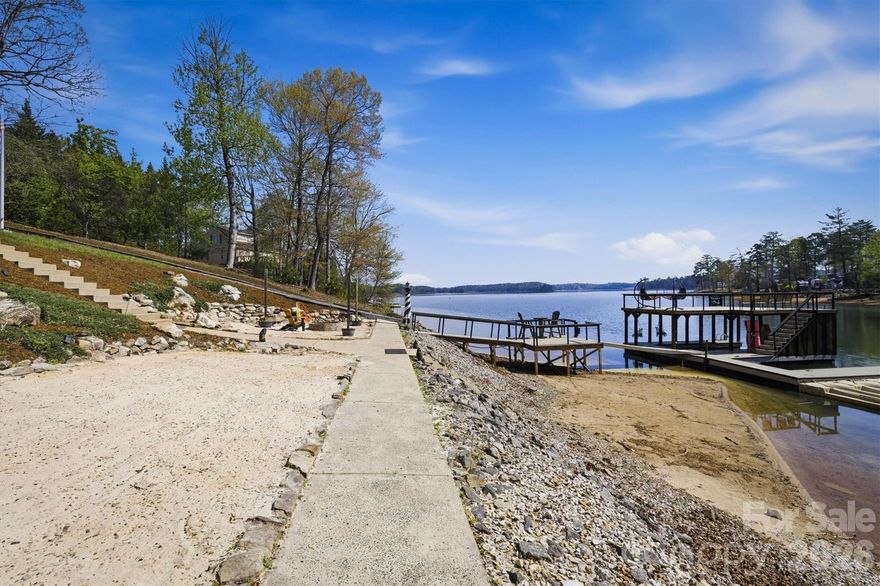 Here's the place on LAKE JAMES YOU'VE BEEN WAITING FOR! This waterfront home is located on a very gently sloped lot offering easy access (also a golf cart path to the water) to its own personal BEACH AREA and DOUBLE DECKER DOCK. The home's dock boasts a covered slip, HUGE TOP LEVEL, uncovered 2nd slip, 3 jet ski ports, recently updated poles, Veka decking, electrical, and floats, all in a no-wake zone. You will love this home's layout, offering 1 level living with a full basement. Upon entry, note the main-level open water views from the entire back of the home, with open concept living, dining, and kitchen all under vaulted ceilings. Beside the kitchen is the perfectly placed updated half bath. Also on the main level is the primary bedroom with 2 walk-in closets and a private ensuite bath. Updates to the home in the past 4 years include the roof, gutters, back composite deck, windows, interior/exterior paint, fireplace, flooring, quartz counters, landscaping, lighting, and more. Spread out and entertain with ease, having a finished basement with a full bath, 2 bedrooms, storage, laundry room, and family room. Even better, in 2024 this home received a major upgrade...a nearly 800 sq ft Veka PVC covered deck. The deck will impress...vaulted tongue-and-groove ceiling, infinity railing, and AMAZING OPEN WATER VIEWS. Underneath the upper deck, find a huge poured patio with a dried-in roof so you can enjoy the upper and lower area rain or shine! Next to the water's edge is a great fire pit area and your very own beach! This home is located in Burke County in the sought-after Laurel Pointe community with low HOA's and no city taxes!