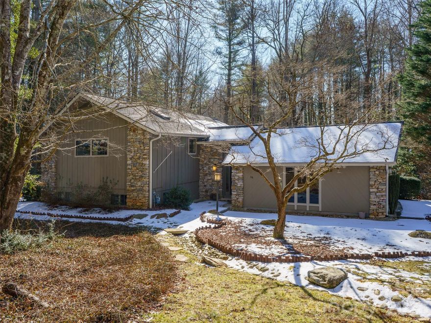 Located in a convenient and charming neighborhood, 138 Woodhaven offers plenty of living space with an open layout on the main level that features vaulted ceilings and an abundance of natural light. Stay warm by the stone fireplace in the living room or relax while you take in the sun on the back deck. The large primary bedroom is also on the main level and features a spacious walk in closet and en suite bathroom. The finished basement with two bedrooms, a full bathroom, washer and dryer, and more, offers plenty of space for family, friends, and entertainment. The ample garage and attached workshop offer plenty of space for parking and storage. Large lots, mature landscaping, and underground utilities create a naturally pleasing aesthetic in this desirable neighborhood that is an easy drive to Hendersonville, Brevard, Dupont State Park, and Pisgah National Forest.