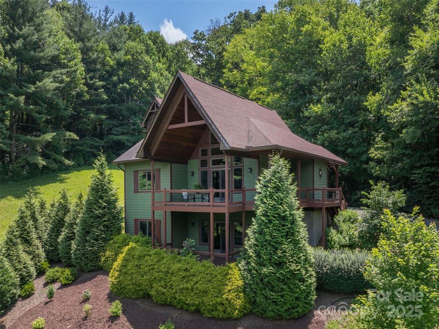 Tucked away in the heart of the Blue Ridge, this enchanting Arts & Crafts home in Waynesville invites you to escape to a world of natural beauty & privacy. Follow the paved drive through 26.94 unrestricted acres of rolling pasture & shaded woods, past the ponds—one crowned by a whispering waterfall—and arrive at a place where serenity meets sophistication. Custom built with thoughtful craftsmanship, the home offers cozy elegance, a double garage on the main level, & sweeping year-round mountain views from every angle. Wander the land, explore the barn & outbuilding, or simply enjoy the view—there’s even room to bring along farm animals or horses to make it your own. Just minutes from the interstate & the gateway to the Great Smoky Mountains National Park, with Asheville an easy half-hour away—this hidden haven offers the perfect blend of peaceful retreat & everyday convenience.