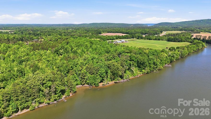 A truly one-of-a-kind offering, this income-producing blueberry farm spans more than 65 acres along the scenic banks of the Tuckertown Reservoir, with nearly 2,200 feet of riverfront creating an unparalleled private retreat. Blending natural beauty with investment potential, the property delivers a rare opportunity to own a working farm while enjoying a refined residential lifestyle surrounded by tranquility and expansive views.

The stately brick residence is thoughtfully designed with both comfort and elegance in mind. Inside, rich hardwood floors, coffered ceilings and a warm fireplace set the tone for inviting living spaces. The well-appointed kitchen features stainless steel appliances, generous cabinetry and a casual breakfast area, seamlessly complemented by a formal dining room and dedicated study. The primary suite serves as a private sanctuary, complete with tray ceilings, a sitting area, and a spa-inspired bath with dual vanities, soaking tub, walk-in shower, and dual walk-in closets. Secondary bedrooms are spacious and well-positioned, while a partially finished basement with an additional fireplace offers flexibility for recreation, storage or future customization.

Outdoors, the lifestyle truly unfolds. A spacious screened porch invites you to take in peaceful views of the surrounding landscape, while the expansive acreage provides endless opportunities for recreation, farming or future vision. A barn with covered parking and equipment storage supports the property’s agricultural use, making it as functional as it is picturesque.

With its rare combination of income potential, extensive river frontage and refined living spaces, this exceptional estate offers a distinctive opportunity to experience life on the water at River Run!