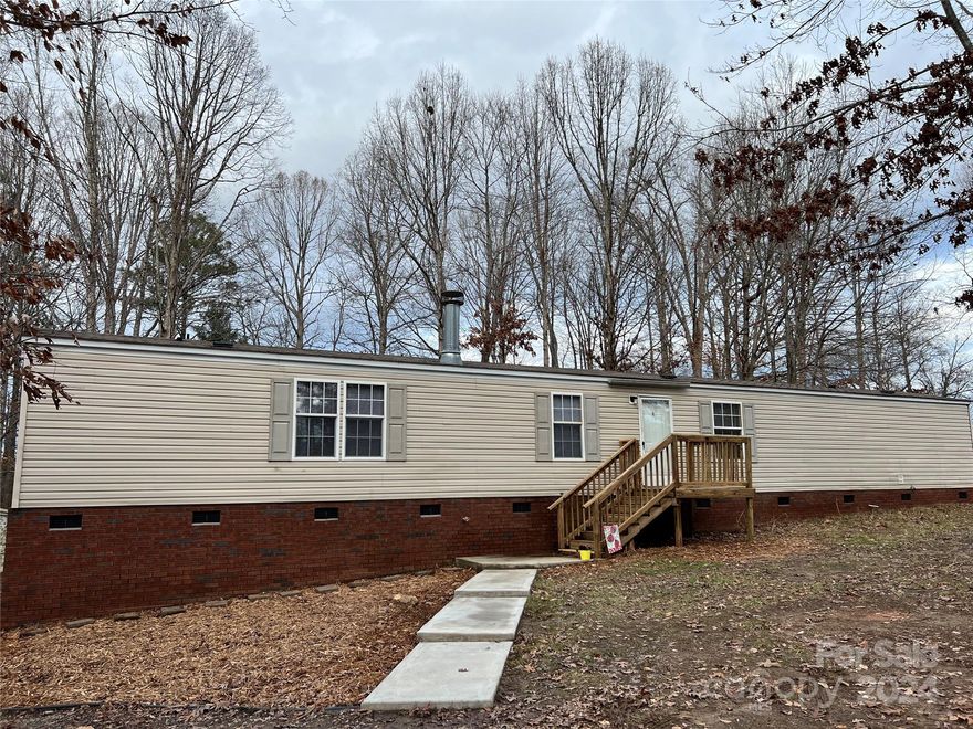 Convenient to Charlotte, Highway 16, Denver and Huntersville, this beautiful, wooded, spacious property is on a dead end street.  New carpet in all bedrooms and hall.  New dishwasher, new soaking tub in Primary Suite, new toilet, 2 new sinks, new faucets throughout, all new paint, and new blinds.  Screened in back deck overlooks wooded backyard.  Two outbuildings, one is wired and is 18' x 19'4".  This mobile home is 15' wide, wider than most singlewides and has lots of natural light.  The Primary Suite has a large walk-in closet and a roomy bathroom with linen closet.  This home is move in ready.