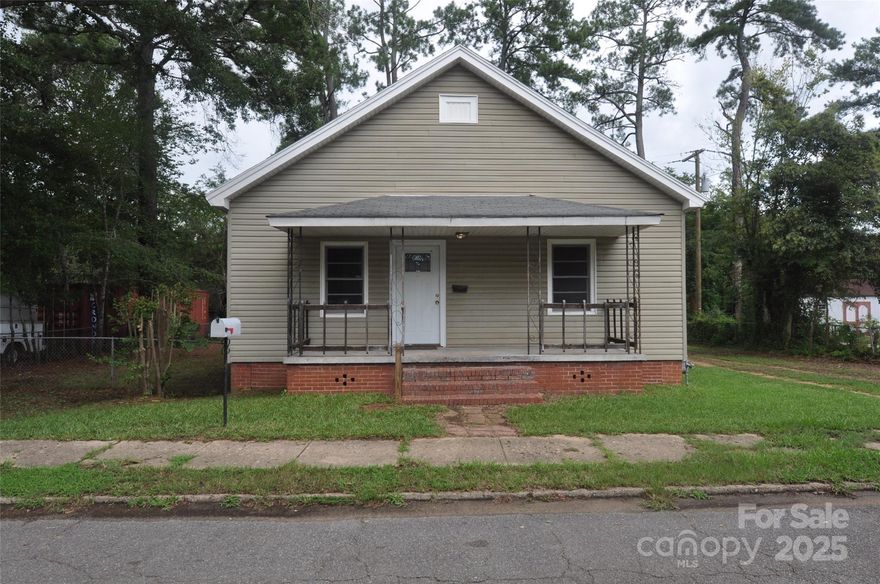 Charming 2-bedroom, 1-bath home with the benefit of low county taxes! The inviting living room features a built-in bookcase and a beautiful brick fireplace façade, creating a cozy atmosphere. Enjoy cooking in the spacious kitchen with ceramic tile flooring, an electric stove, and a built-in microwave. The interior has been freshly painted in neutral tones, offering a clean and modern look. The bathroom includes a tub/shower combo and a double-sink vanity for added convenience. Outside, you'll find a fully fenced yard and a generously sized driveway. This move-in ready home is ideally located with easy access to both Charlotte and Columbia.