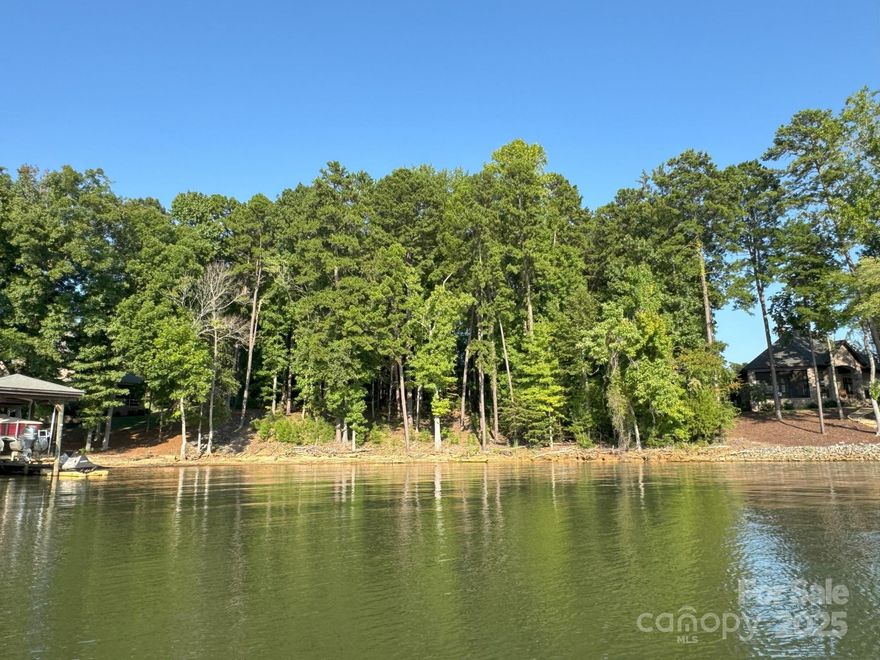 Gorgeous sunset views from this large dock-able Waterfront Lot in Reflection Pointe on Lake Wylie. This 0.63 acre lot gently slopes to a sandy beach, combining its small cove location with beautiful views of both the South Fork and Main Channel of The Catawba. The center portion of the lot is wider than most similar lots in the subdivision. Lot is located near the subdivision shared beach area with a marina, large pavilion, restrooms, and grilling area. Reflection Pointe is a gated community nestled along the shores of Lake Wylie including amenities such as the lovely clubhouse, a large lagoon style pool with splashpad, lighted tennis courts, playgrounds, soccer/recreational fields, paved trails traversing 20 fountain equipped ponds, and even a gated boat/rv storage lot. Explore Belmont’s restaurants, boutiques, breweries, and retail shops. Just a short commute to Uptown Charlotte and the Charlotte Douglas Airport. Lots on both sides available and could be combined.