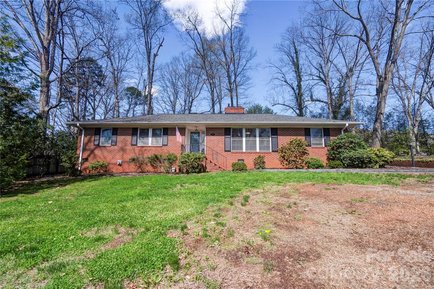 Charming brick/vinyl 3-bedroom, 2-bath home offering a functional layout, spacious rooms, and excellent curb appeal, backing up to the City of Shelby Golf Course. The living room features a fireplace with gas logs, while the kitchen offers a breakfast area, walk-in pantry, and easy access to the formal dining room and an additional den, perfect for entertaining or flexible living space.  A large mudroom with sink and laundry closet adds everyday convenience. Hardwood floors run through most of the home, and the updated hall bathroom adds modern appeal.  Outdoor features include nicely landscaped grounds, a fenced rear yard, a 2-car attached carport, and a large concrete area providing ample additional parking. A partial basement offers extra storage, and a tankless water heater adds efficiency.  Storage Building in rear yard for added storage or workshop.  This is a must-see—schedule your showing today!