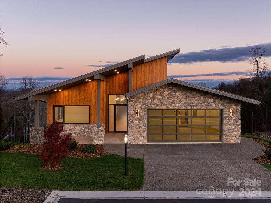 Located in the new exclusive mountaintop enclave of Summit Vista at Carriage Park, this recently completed mountain modern home was designed for seamless lock-and-go living. Offering unmatched views of the surrounding Blue Ridge Mountains yet situated on one of the flattest sections of the community, it is designed for ultimate comfort and accessibility. Luxurious detailing includes vaulted ceilings, white oak floors, modern pendant lighting, IPE decking, and a fabulous, chef-inspired kitchen with polished quartzite countertops, custom cabinets, high-end appliances, plus a back kitchen with a large walk-in pantry. The easy open floor plan features high-performance Oknoplast windows and double rear porches to enjoy the stunning views all year round. Only 7 minutes from Historic Downtown Hendersonville and just 9 miles to Asheville Airport, this is relaxed, mountain retreat living at its finest, where convenience meets sophistication.