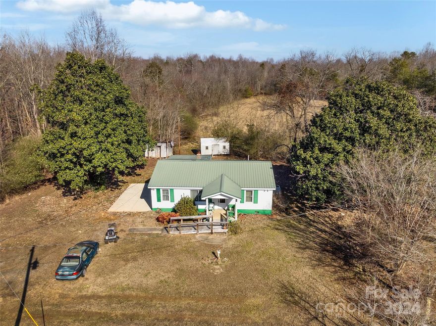 WE'VE IMPROVED THE PRICE AGAIN! Make an appt! Escape to your own piece of rural paradise just 45 miles north of Charlotte with this expansive 12-acre property. Nestled amidst serene farm land, this property features a spacious cinder block 3-bedroom home, offering the perfect blend of comfort and durability. With both cleared land and wooded areas, there's ample space for farming, gardening, or simply enjoying the natural surroundings. Situated just 30 minutes from Lake Norman, outdoor enthusiasts will delight in easy access to the park's recreational activities. This home has minimal steps for ease of mobility. While it may require some updating, there're hardwood floors under the carpets, the potential is boundless. Whether you're dreaming of a peaceful retreat or a working farm, this property offers endless possibilities for realizing your vision in the heart of North Carolina's countryside. Explore this opportunity now! **According to Dept. of Health, septic permit is unavailable.