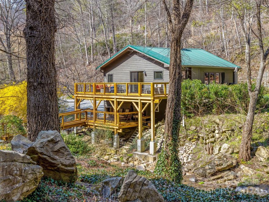 Rare gem of a home and property on 13 acres in the desirable East Fork Community, centrally located between Marshall and Mars Hill. Sights & sounds of being by the creek welcome you into this turnkey home with every detail meticulously thought of. Enjoy numerous updates throughout the house, including newly replaced creekside decks well positioned to enjoy the views over the peaceful waters and vast landscape. Trails and infrastructure plan in place for camping and future build. Mature perennial landscaping includes multiple variations of bulbs, flowering trees, & shrubs highlighted by pronounced autumn colors. Abundant wildlife, including fish in the creek, and a healthy population of pollinators! Step off the deck to your own tranquil retreat of swimming holes, moss and fern laden grounds, accented by stunning boulders. Come experience this wonderful place for yourself while it's still on the market. 25 mins Asheville. https://iframe.videodelivery.net/80f5d363c1ebb1d5034b85940ec4ac78