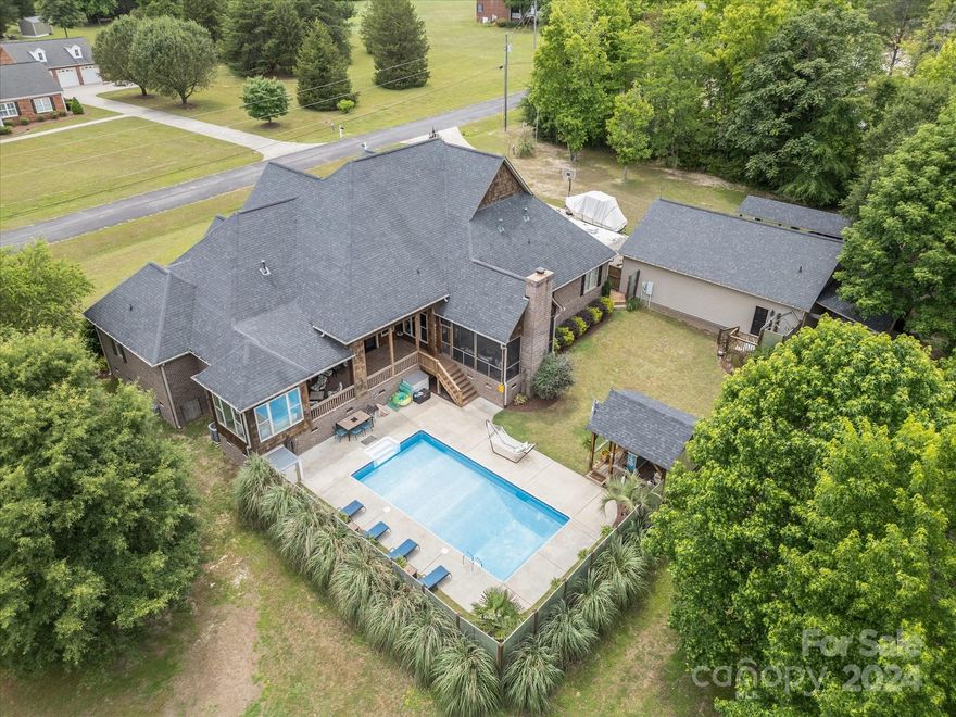 A perfect piece of paradise awaits! This sprawling 4 bedroom, 4.5 bath has it all! The open floor plan boasts an expansive living room with vaulted ceiling, custom built ins and a fireplace to get cozy by! Prepare your favorite meals in the chefs kitchen, complete with granite, stainless appliances, island, walk in pantry and eating area! The formal dining is ready for hosting all your friends and family! The luxurious primary suite has a sunroom/sitting area, walk in closets, a bath with walk in shower, double sinks, soaking tub and water closet! Three more bedrooms, three more full baths, laundry room and office area finish off the main level! Upstairs is a huge bonus room with bar, area for a pool table and a half bath! Spend your days sunbathing by the pool or taking in all four of our sweet southern seasons on the covered back porch and screen porch! There’s room for all your toys and tools in the detached garage with workshop area and a half bath! You won’t want to miss this one!