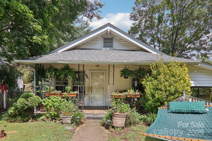 Charming bungalow full of historic character just steps from the heart of West Asheville! Brand new floors in kitchen and bath, along with other bathroom updates. Original hardwoods throughout rest of the home. This home features a welcoming covered front porch, charming original details including original hardwood floors, a sunroom overlooking the backyard, and plenty of natural light. Enjoy outdoor living in the fully fenced yard—perfect for pets, play, or gardening. The carport offers convenient off-street parking. A rare opportunity to own a home so convenient to Haywood Rd but tucked away and more private than most other homes on Nevada Ave. Just minutes from all the shops, restaurants, and cafes along Haywood Road, this home combines vintage charm with unbeatable convenience.  There is a peak of a mountain view from the back sunroom that would prove to make beautiful mountain views if you were to add an upstairs viewing deck or second level addition! Just a 1 minute drive or 4 minute walk to Sunny Point Cafe! 10 minutes from the River Arts District, Downtown Asheville, and Biltmore Village!