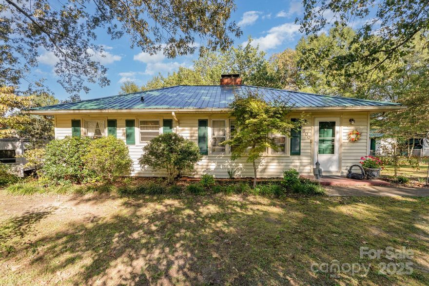 Welcome home to cozy one story living! Just a short distance from downtown Gastonia, this home is perfect for the modest lifestyle. The home features great curb appeal with flower beds, mature shade trees, a detached deck, a detached one car garage with wood burning fireplace and metal roof, a fenced in back yard, and an asphalt driveway. Our lot size stands out compared to most other homes in the area. Outside also includes a 2025 year metal roof, painted shutters, a back porch for peaceful sitting. Inside you will find two spacious bedrooms, a bathroom that includes the washer and dryer, hardwood floors, renovated kitchen with stainless steel appliances, a dining area featuring lots of highly desirable natural light along with a wood burning fireplace. Spend your evenings relaxing in the living room around the gas log fireplace. This home has everything that should make you want to take a tour!