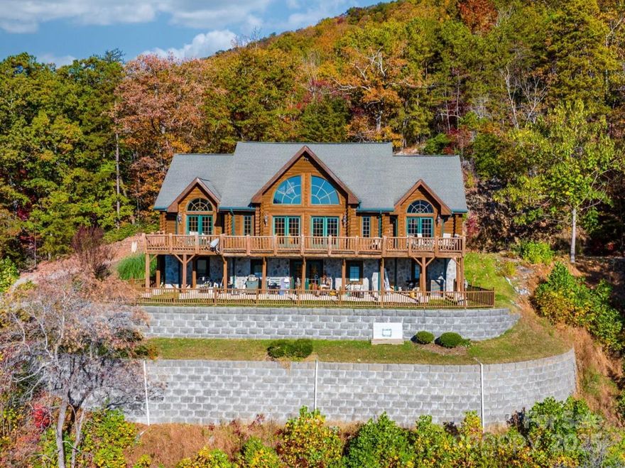 Motivated Sellers!! Remarkable log home with breathtaking views situated on 12 acres in the Austin Creek Community. Upon entering, you will find a spacious living area, stunning stone fireplace, towering ceilings and beautiful log beams. The main level also features a powder room, oversized primary suite, kitchen with a farmhouse sink and antique stove, dining and sitting areas. Step out onto the enormous deck with immaculate panoramic views year-round. Upstairs you will find an open loft area, bedroom and bathroom. The lower level is fully finished and offers a secondary living space with a family room/game room, bedroom, bathroom, bonus room, den, laundry and workshop area. Various elevations and terrain afford privacy with the potential for additional structures. The utility, workshop and storage areas have a ceiling height just under 7ft. Convenient location minutes from Lenoir and close proximity to Boone and Blowing Rock. More information and notes found in attachments on MLS.