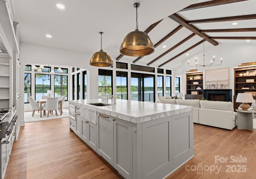 Welcome to refined lakefront living in the exclusive gated community of Edgewater. This custom masterpiece pairs timeless elegance with modern craftsmanship, offering honed Calcutta marble countertops with brass inlay, Distinctive Design cabinetry, and Thermador appliances in a show-stopping kitchen with a creative butler’s pantry. The main floor features a serene primary suite with lake views, travertine balcony, and spa-like bath with hand-cut tile, soaking tub, and custom closet. A guest suite and flexible office/bedroom complete the main level. The entertainer’s basement features a full bar, wine room with custom cooling system, two private ensuites, and potential gym/theater space. Designer lighting, polished nickel and brass fixtures, hand painted wood Pella windows, and room for a pool elevate this exceptional home. 1 point buydown being offered with preferred lender. 10 Year Structural Warranty to convey. Community features Olympic size pool, club house and lakeside pavilion.