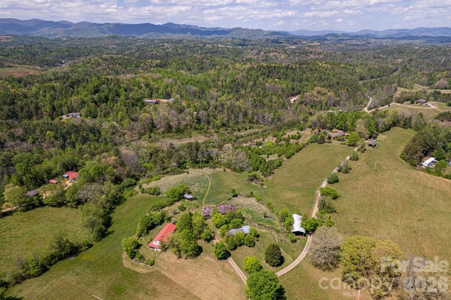 Absolutely stunning 35± acre property offering everything you’ve been searching for. This exceptional tract features rolling, usable land with breathtaking long-range mountain views, a small stream winding through the property, and a peaceful pond.  Multiple ideal building sites provide the perfect setting to create your dream estate, whether you’re seeking complete privacy or sweeping views. Existing home with barns and outbuildings offer excellent potential for a working homestead, hobby farm, or equestrian use, while the current home allows for immediate enjoyment or future customization.  With Open Use County zoning and a prime location just minutes from Asheville and Weaverville, this property offers unmatched flexibility and convenience. The possibilities here are truly endless.