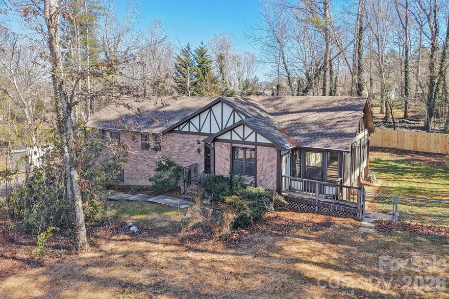 Classic Tudor-style charm meets modern updates in this beautifully refreshed split-level home in the heart of Fletcher. Situated on a spacious .61-acre lot with a fenced backyard and no HOA, this property offers room to spread out inside and out.

Built in 1982, the main level features 1,662 square feet with three bedrooms and two full baths. Fresh flooring runs throughout, giving the home a clean, updated feel. The kitchen has been upgraded with new appliances and new countertops and flows seamlessly into the dining area and family room. A wood-burning fireplace creates a warm focal point in the family room, perfect for cozy evenings.

Just off the dining area, a 234-square-foot three-season room provides additional space to relax and enjoy views of the backyard, with easy access to the rear deck for grilling or entertaining.

The lower level adds 944 square feet of flexible living space, including a spacious great room with a second wood-burning fireplace, a bonus room ideal for an office, gym, or guest area, a full bath, and a laundry room. An oversized two-car garage offers excellent storage and workspace.

Located in the Glen Arden Elementary, Cane Creek Middle, and T.C. Roberson High school districts, this move-in ready home combines character, updates, and a prime Fletcher location just minutes from Asheville, Hendersonville, and the airport.