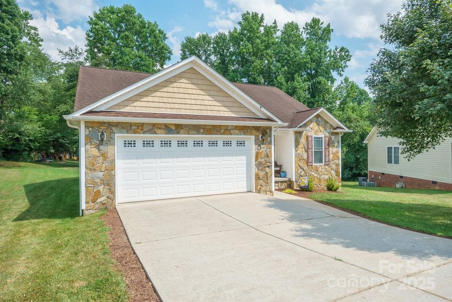 This ranch has everything you need. Built in 2008 with only one owner, this home features a sidewalk-lined street and a low-maintenance exterior of rock and vinyl. Inside, beautiful hardwood floors are in the great room with a gas-log fireplace. The kitchen has a seated bar (stools remain), a pantry, dark cabinets reaching to the ceiling, a corner sink overlooking the backyard, a 2020 dishwasher, and a 2025 refrigerator that remains. The dining area boasts a large window and a door leading to the deck. The split floor plan is ideal. The primary suite is on the left with a private bath featuring dual vanities and his-and-her closets. Bedrooms II and III share a hall bath. The laundry room is conveniently located on the same side as the primary bedroom. The spotless 2-car garage includes a storage closet. This lot is larger than most and offers a spacious backyard for your enjoyment. Step out onto the deck and enjoy working in the yard and privacy.