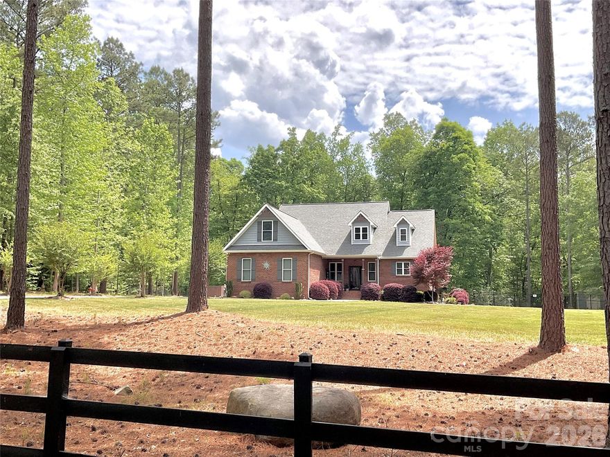 Welcome to this beautifully custom built full-brick gem on 5+ Acres in picturesque country setting in Clover. This home has been loved with care and style. As you enter, you'll be greeted by a two story entryway, open concept Great room with Custom built-in shelves & storage surrounding the two story stone fireplace with views to the tree-lined backyard. With a Chef's kitchen featuring high-end appliances, large island, beautiful countertops, custom cabinetry perfect for anyone who loves to cook or entertain. Plenty of room to gather in the eat in kitchen overlooking the private backyard. The open-concept layout flows with natural light, giving the living spaces a warm, inviting feel. The primary suite is a true retreat with 2 walk in closets, spa-like bath, soaking tub, double vanities and  a spacious walk-in shower is a perfect place to unwind. Upstairs find two bedrooms, full bathroom, an additional very large flex room over 2 car garage ideal for office, hobbies, or a great guestroom with a walk in closet. Outside, the landscaped, fenced yard is ready for everything from barbecues to quiet mornings with coffee on the relaxing screened porch and soak in the fabulous Custom 14 x 33 Fiberglass heated saltwater pool. The front porch & garage floor have epoxy covered floors. Custom built and so convenient, owners added  elevated overhead storage in garage. Top-rated schools! There are NO HOA only covenants, Can have an ADU but not room for it off the LEFT OF driveway but can be built on many other locations on the property. The septic is in the front yard. Plenty of room on the right, the back or off the back left behind the pool.