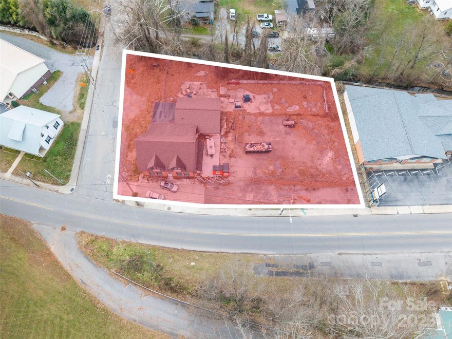 Prime corner location in the heart of downtown Waynesville, fronting highly visible N. Main Street with exceptional traffic exposure and easy access. This impressive 4,400+ sq ft all-brick commercial building sits on a generous lot and features a recently updated architectural shingle roof, modernized plumbing and electrical systems, refreshed bathrooms, and a thoughtful new floor plan designed for maximum flexibility. The standout outdoor patio area creates an inviting space perfect for guest seating or events, while approximately 45 premium paved parking spaces ensure convenience for customers and staff. A kitchen area is already roughed-in with plumbing and power, making this an ideal turnkey opportunity for a restaurant, brewery, professional office, medical practice, or retail destination. Rarely does a property combine this level of recent improvements, parking capacity a premium , and high-visibility corner placement in Waynesville’s vibrant core. Move-in ready and poised for immediate success.