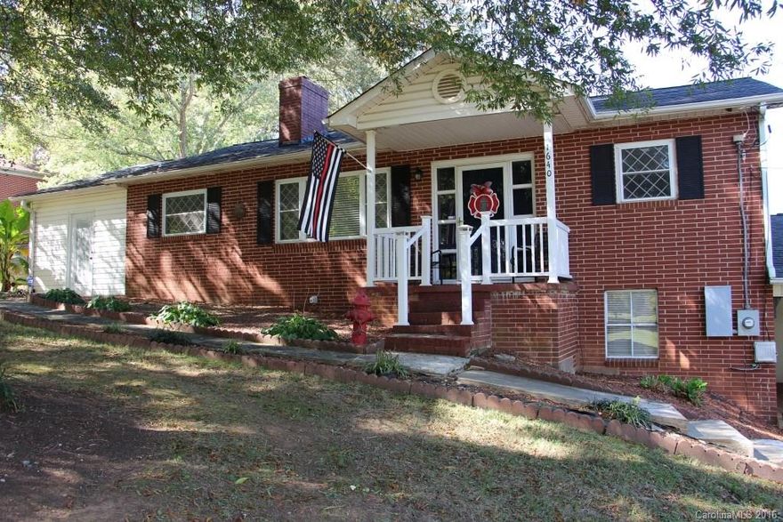 Brick ranch w/full, unfinished basement & fenced-in back yard. 3 BRs & 1 full BA. Living room has tongue & groove walls, hardwood flooring, stone, floor-to-ceiling FP. Kitchen features tile flooring, eat-at bar, ss appliances & large dining. Full bath offers double vanity sinks & double linen closets w/ tile flooring. Laundry hookups are located in enclosed, unheated side porch area. Double attached carport & single garage in basement. Outbuilding & shed are in the large fenced-in back yard.