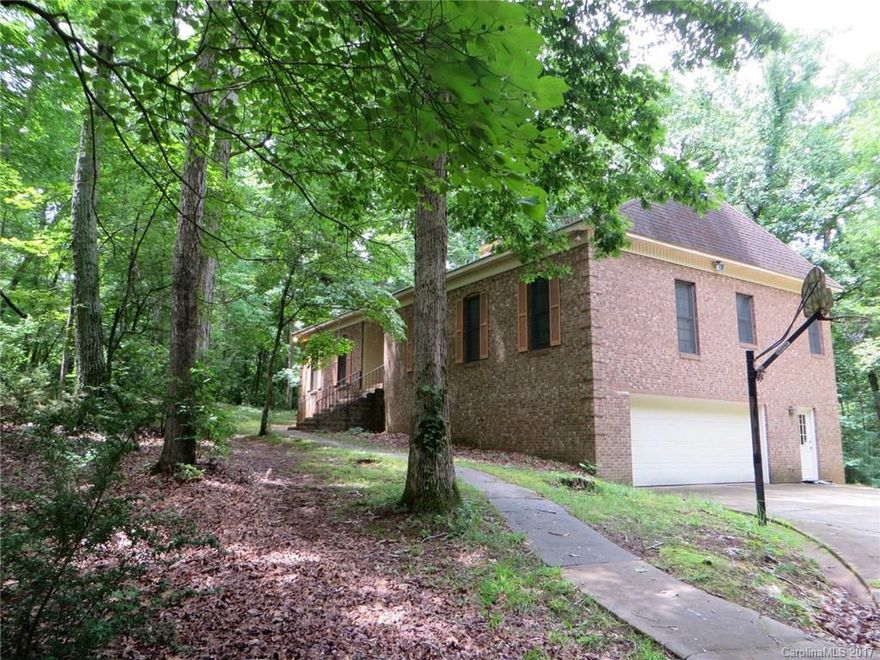 Complete & total privacy on 4.5 acres less than 10 min from I-485!  Full brick ranch w/spacious rooms throughout + a walk-out basement (with bath) that could be finished for even more square footage. 2 car garage, work shop. LR w/ FP open to DR. Kitchen has tons of storage, island w/ cooktop, new dishwasher.   Great outdoor living space - deck, patio & screened porch w/wooded views. One-owner home, well maintained, no cosmetic updates but lots of potential to turn this into your dream home.