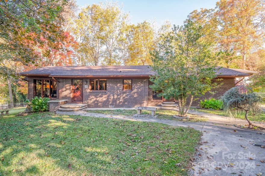 Enjoy single-level living just minutes from downtown Black Mountain! This 2 bedroom, 2 bathroom home is situated on .64 acres with mountain views and an outdoor fireplace perfect for entertaining. The backyard is fenced and has a storage/carport area. There is a detached 2 car garage with a partially finished area on the second floor that could be used for additional living space, studio, or workshop.