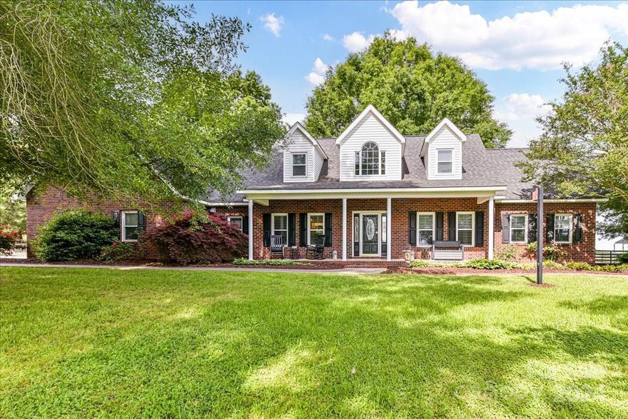 Welcome to your dream home nestled on approximately 5 acres of picturesque landscape! This full-brick updated home offers the perfect blend of modern luxury and serene countryside living. Stunning sunrises and sunsets await you! Sip your morning coffee or unwind in the evenings on the rocking chair front porch, soaking in the tranquility of your surroundings. Enjoy the convenience of having the primary bedroom located on the main floor. Primary bath w/soaking tub and decorative tiled shower. Open kitchen and breakfast area w/designated dining room. Family room w/gas logs. Plantation Shutters throughout most of the main floor. Spacious secondary bedrooms upstairs. Large bonus room w/closet is being used as a bedroom w/private staircase. Large powder room w/shower on main, shower not permitted. Garage is currently being used as an office, kitchenette and pantry but can easily be converted back. HVAC units replaced in 2021& 2024. 20x20 outbuilding w/200amp electrical service.