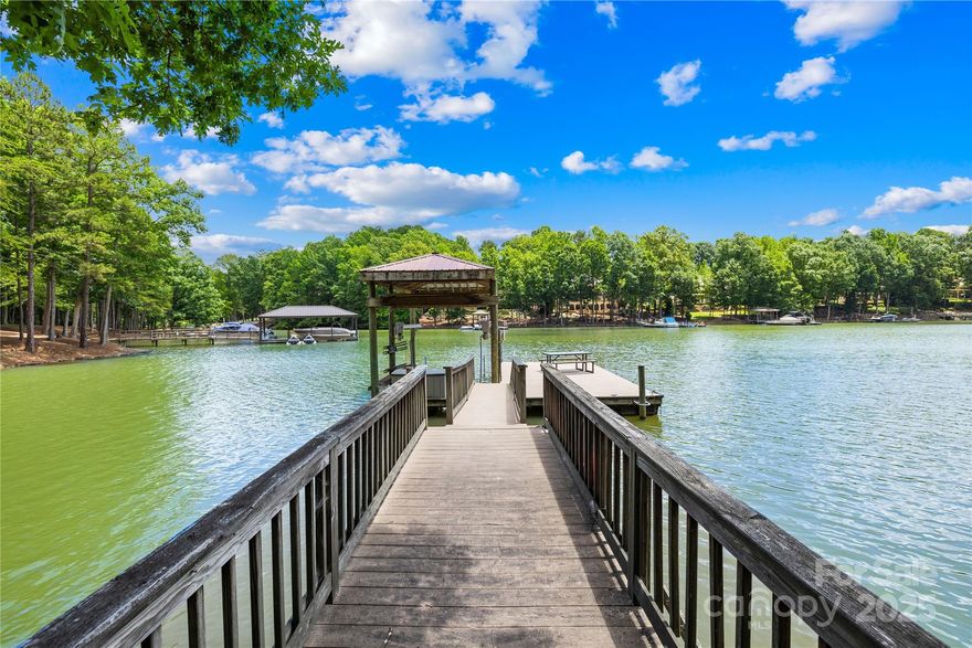 Lake Life is Calling! Welcome to 228 Wildwood Cove Drive—where sunshine, serenity, and the best of Lake Norman living come together. This beautifully designed home combines comfort, style, and functionality with main-level living, lake views, and deep-water access. Whether you’re seeking a full-time residence or the perfect lake retreat, this property has it all.  Main Level Living & Stunning Views! Step inside to soaring ceilings and a dramatic 2-story great room filled with natural light. The main-floor primary suite features beautiful lake views, a spacious layout, and direct access to outdoor living spaces. A well-equipped kitchen with stainless steel appliances, abundant cabinetry, and a large walk-in pantry make entertaining and everyday living a breeze. One of the home’s most loved features? The newly added covered porch—perfect for enjoying morning coffee, evening sunsets, or gatherings with family and friends, rain or shine. The upper level includes three generously sized bedrooms, a jack-and-jill bathroom, and a second ensuite, offering privacy and flexibility for family or guests.  Walkout Basement Retreat awaits! The finished basement is designed for fun and relaxation. A large family room, second kitchen with bar, movie theater, flex room, and covered patio with a hot tub create the ultimate entertainment hub. New flooring and fresh paint (2025) make it feel brand-new. Lakefront Living at Its Best! Step outside to your private covered dock with boat lift in a quiet, deep-water cove—approx. 8 feet at full pond—so you can enjoy year-round boating. The property offers space for a possible future pool, and with the septic field conveniently located across the road. This home has been beautifully maintained and thoughtfully updated, making it truly move-in ready:  New roof (2024), Fresh interior paint throughout (2025), New carpet in the primary suite (2025), New basement flooring & paint, Newly renovated garage with epoxy floor (2025), Covered deck addition with rubber membrane & storage below (2024), 3 HVAC systems (one condenser replaced 2018), 2 hot water heaters: large unit for bathrooms (2020), smaller unit for kitchen/laundry/basement bar (2022). This is a LAKE lifestyle & highly desired location. Enjoy low county taxes, modest HOA dues, and the benefit of an assumable VA loan at 2.99% (for qualified buyers). The property’s location is unbeatable—close to shopping, dining, schools, and major highways, while tucked into a quiet cove that offers privacy and tranquility.
Why You’ll Love It? Main-level living with lake views, Entertainer’s dream basement with theater & second kitchen, Covered porch & patio with hot tub for year-round enjoyment, Deep-water covered dock with lift—use your boat all year, Updated, move-in ready, and filled with storage. This home truly offers the best of Lake Norman waterfront living—from summer fun on the water to cozy evenings by the fireplace. Come experience it in person and see how this property blends elegance, comfort, and the lake lifestyle you’ve been dreaming of. Come see this waterfront home for yourself and enjoy 'Lake Life' on Lake Norman in 2025!