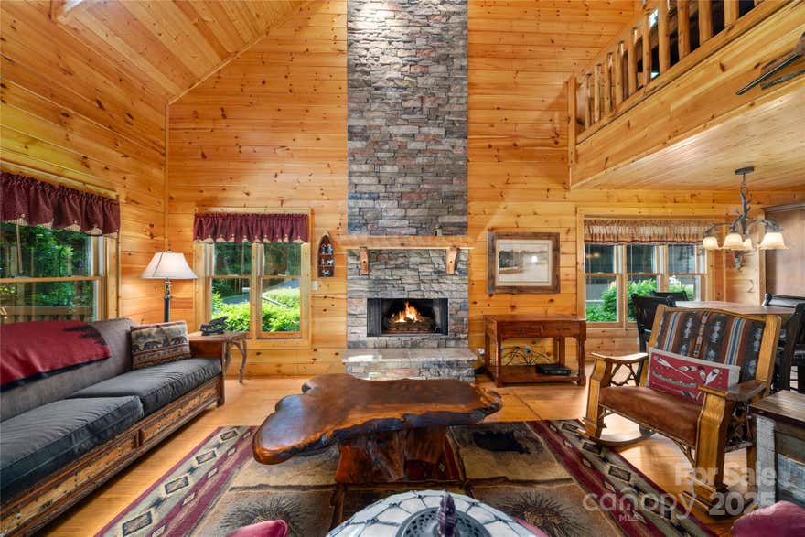 Welcome home to your Creekfront "Cabin" in Maggie Golf Club! Imagine waking-up to the gentle rush of a bold stream just beyond your manicured **association-maintained yard** & 2-car garage with workshop. The soaring 2-story great room with a fireplace, vaulted wood ceiling, wood floors, a dining nook, open plan kitchen with granite, stainless and an island create an inviting atmosphere. The main level hosts two bedrooms, a full bath, laundry, screened in back and a front porch, perfect for relaxing by the creek. Upstairs, a loft, full bath, and vaulted-ceiling bedroom provide ample space. This charming wood cabin includes a 'sports' membership for golf club living. Available fully furnished and decorated for $5,000 (and a golf cart for $2,000!), this ready-to-rent retreat is in walking distance to golf, pool, fitness, and dining. Enjoy easy access to Asheville, Cherokee, the Great Smoky Mountains, and historic Waynesville from this incredible, quality-built home. Outside of closing - Fully furnished with golf cart.