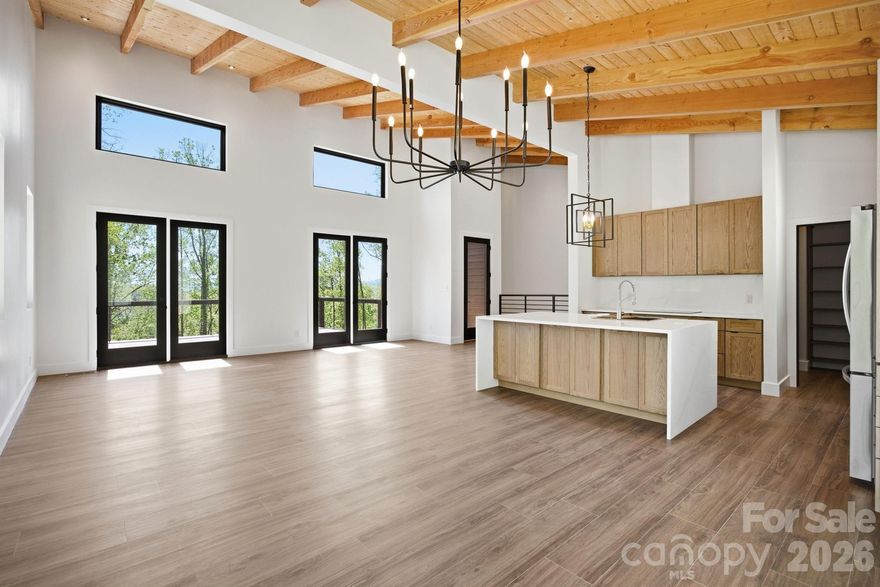 NEW PRICE - Experience the difference of modern mountain living in Hendersonville NC!  Newly constructed modern mountain home located in the desirable Beechwood Lakes Community.  Built with quality in mind, this 3-bedroom,3.5-bath home blends modern architecture with warm, high end finishes throughout. Soaring vaulted tongue-and-groove ceilings, wide-plank luxury flooring, and a striking ebonized white oak staircase create an inviting interior with a strong sense of craftsmanship.  The kitchen is a true focal point, featuring custom cabinetry, a walk-in-pantry, quartz countertops, a dramatic waterfall edge island, designer lighting and brand new LG stainless steel appliances.  Expansive Andersen Pro Series fiberglass windows and 8 ft French doors flood the home with natural light.  Enjoy effortless indoor-outdoor living with a spacious deck extending from both the main living area and the primary suite-perfect for entertaining or relaxing in a private, elevated setting. The primary bath offers a walk-in closet, glass-enclosed tile shower, dual sinks, and generous vanity space. Designed for both comfort and efficiency, the home includes a durable metal roof and a brand new, high-efficiency 5-ton, 19 SEER York all- electric HVAC system, thoughtfully enhanced with an Aprilaire dehumidifier, ensuring optimal indoor air quality.  The lower level offers versatility, featuring 2 additional bedrooms, 2 full bathrooms, and a generous secondary living space - ideal for guests, family, or flex use.  Conveniently located just minutes from downtown Hendersonville and approximately 30 minutes to Asheville, with easy access to dining, shopping and outdoor recreation. Residents of Beechwood Lakes enjoy exclusive access to private lakes, beach areas and picnic spaces.