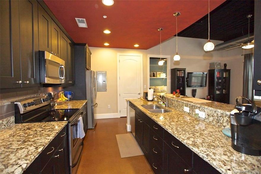 Top floor, 2 BR 2 BA NoDa condo w/true urban appeal.  Don't miss the Uptown views from terrace balcony!  Exposed 12 foot ceilings, 8 foot BR doors for privacy, stamped concrete floors, large walk in closets in bedrooms.  Granite counters in kitchen & bath, gorgeous cabinets & stainless appliances w/designer lighting.  A preferred location in 28th Row plus premium reserved parking space right at entrance front door.  Secured building.  Amelie's Bakery right literally just steps from your door.