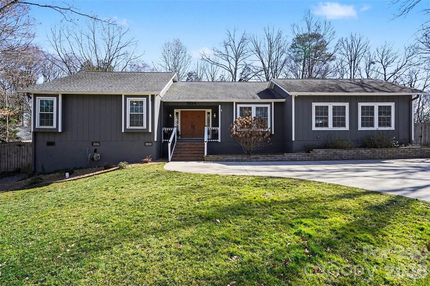 Welcome home to this beautifully updated 3-bedroom, 2-bathroom ranch in the desirable Woodberry Forest neighborhood of Charlotte. Thoughtfully improved during the sellers’ ownership, this home offers comfortable one-level living with both indoor and outdoor spaces designed to enjoy year-round. A covered front porch creates a warm first impression and inviting entry. Inside, the large remodeled kitchen serves as the heart of the home, offering an easy flow for everyday living and entertaining. The dining area is accented by a dry bar, providing additional cabinetry storage and a functional space for serving and entertaining. The cozy living room features a beautiful stone gas log fireplace and a vaulted ceiling with wood beams, adding warmth and character to the main living space. Just off the kitchen, a huge bonus room provides flexible space for a second living area, playroom, home office, or media room. Tucked away down the hall, are the bedrooms and bathrooms. The hall bathroom has been upgraded with a new vanity and a recently reglazed bathtub, while the spacious primary suite features a walk-in closet and private ensuite bath. Major system updates in recent years include a replaced HVAC and water heater, providing added peace of mind for the new owner. The exterior was painted for a modern twist, and most of the windows and interior doors have been replaced for a refreshed, cohesive feel throughout. Outdoor living truly shines here. The large, fully fenced backyard is enhanced by mature trees, and upgraded landscaping and hardscaping in both the front and back. Enjoy time on the refurbished back deck or gather around the newly installed concrete patio and firepit area. A French drain was added in the backyard for improved drainage, and the driveway was repaved to create a flatter parking space at the top for added convenience. This move-in ready ranch blends thoughtful updates, functional living space, and inviting outdoor areas—all in an established Charlotte neighborhood located close to Uptown, Matthews, Southpark and Cotswold. Don't miss out on this beautifully maintained, well-thought out home!