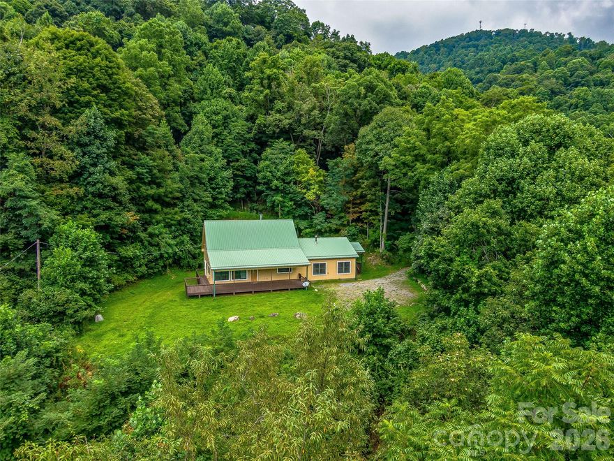 Looking for the ultimate mountain retreat? This cozy cabin on 35 acres offers rare privacy, peaceful seclusion, and endless room to explore. Tucked within a small, like-minded mountain community, the property feels worlds away while still providing the comfort of nearby neighbors who value quiet and space. Wander your own trail system along old logging roads, then unwind beside the stunning stone fireplace that anchors the open living area.  A main-level guest suite provides flexible space for visitors, hobbies, or a home office, while a stairlift offers convenient access to the upper level. The gently usable yard is perfect for gardening or simply enjoying the fresh mountain air. Extend your living space outdoors on the expansive covered front porch—ideal for relaxing and taking in the views.  Perched at over 3,000 feet in elevation, enjoy cooler temperatures, serene surroundings, and a true sense of escape. Perfect as a second home or private retreat for nature lovers and outdoor enthusiasts. No drive-bys; appointment required.