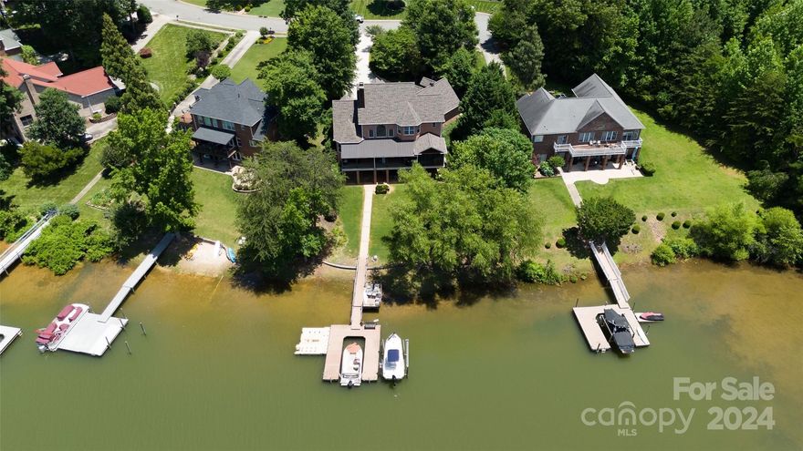 The Luxury Enclave community presents an exceptional living experience, with this stunning property perfectly situated on the serene shores of Lake Norman. Nestled in a quiet cul-de-sac, this elegant two-story home features a fully finished basement, complete with a second kitchen, ideal for entertaining or extended family living. Enjoy the expansive enclosed patio, which includes a state-of-the-art outdoor kitchen, perfect for hosting gatherings year-round. Ensure your boats and wave-runners are safely stored with the two boat slips, the two wave-runner lifts, and the easy-access lift. This waterfront property promises breathtaking views and direct access to the lake, offering a unique blend of luxury, comfort, and natural beauty. Custom-built and private, perfect for lake living and endless lake fun.