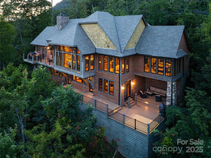 A masterpiece of design and craftsmanship, this custom estate captures sweeping vistas of the Blue Ridge Mountains while embodying a standard of refined luxury rarely seen. Conceived by a distinguished architectural studio and brought to life by Towery Builders, every detail of the residence reflects an uncompromising commitment to artistry, quality and livability.New Roof Installation in 2024. From the moment you arrive, the home’s commanding presence is matched only by the serenity of its setting—in the gates of Southcliff, Asheville’s premier mountain community. The interiors unfold in expansive, light-filled living spaces where walls of windows frame breathtaking views at every turn. The open-concept design draws the eye outward, blurring the line between indoors and nature’s grandeur. In the great room, soaring ceilings, fine finishes, and abundant natural light create an atmosphere dramatic and inviting. The seamless flow continues into a bespoke chef’s kitchen, where handcrafted cabinetry and millwork by renowned artisan Greg Paolini elevate function into art. Large picture windows above the sink and prep spaces ensure even daily routines are infused with the inspiration of ever-changing mountain panoramas. Entertaining is effortless here, with spaces designed to accommodate intimate gatherings and grand celebrations. Generous decks expand the living environment outdoors, inviting moments of quiet reflection or lively evenings under the stars, all while surrounded by layers of rolling ridgelines. A wine cellar, crafted for connoisseurs, adds to the home’s capacity for refined hosting. The private primary wing is a sanctuary of elegance and tranquility, offering its spectacular views and a spa-like bath retreat. With four bedrooms and three-and-a-half baths, the home provides ample accommodations for family and guests, each space graced with thoughtful details and an enduring sense of comfort. Southcliff itself enhances the lifestyle, with 24-hour security, direct access to six miles of manicured hiking trails, and a rare blend of privacy and community. Just 10 minutes from Asheville’s vibrant downtown, residents enjoy world-class dining, art and culture within easy reach, while returning home to a setting of elevated serenity. Here, mountain living is redefined. Elevated, spacious and without compromise, this Southcliff estate is more than a home—it is a statement of vision, craftsmanship and connection to the land.
