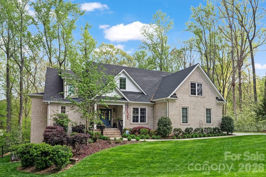 Built in 2021, this FULL BRICK home in Water Edge offers 7 bedrooms, 5.5 baths, abundant STORAGE, and a highly functional floor plan across three finished levels. The main level features a chef's kitchen with a 48-inch WOLF GAS range, SUB-ZERO refrigerator, custom cabinetry, leathered quartzite island, and a hidden walk-in pantry. A dedicated office and spacious primary suite with tree views, dual walk-in closets, and a spa-style shower complete the main level. LVP flooring on main and upper floors. Engineered hardwood and new carpet in the basement. Upstairs includes four LARGE additional bedrooms and two full baths. The walkout basement offers exceptional flexibility with TWO bedrooms, each with its own full bathroom and walk-in closet, a full second kitchen, a living area, a laundry hookup, and a home theater setup.

The backyard earns its own tour. The heated SALTWATER POOL with travertine coping and an elevated spa finished in stacked stone. A pergola with a bar sits at the far end of the patio, with mature trees offering plenty of privacy. A dedicated heated and cooled full bath with private exterior access enhances the outdoor living experience, offering added convenience for pool guests and entertaining. And off the main level, a brand new Trex deck sits elevated above the backyard with views of the pool below. A three-car garage with new epoxy flooring ties it all together. 
Water Edge amenities include a LAKESIDE clubhouse and community pool, with convenient access to Charlotte.