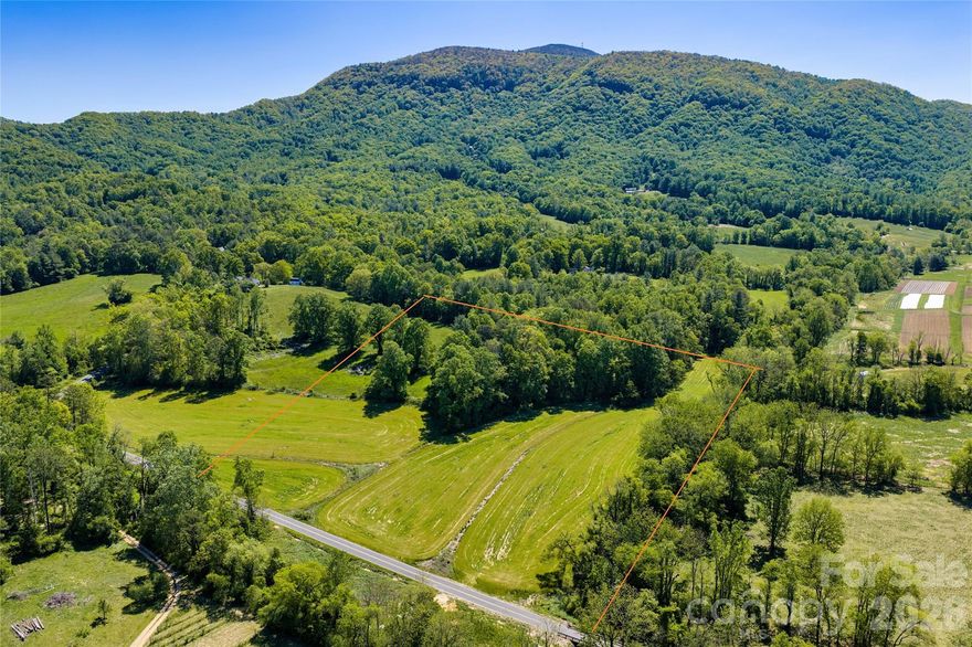 Rare opportunity to own a private 10-acre estate parcel in the heart of Fairview’s highly sought-after Cane Creek Valley. Tucked along Sugar Hollow Road and bordered by Asheland Creek, this property offers a unique blend of pastoral beauty, natural water features, and long-range mountain presence.

The land rises gently to a single, exceptional homesite positioned at the top of the property—nestled within an old-growth forest for privacy while capturing sweeping views of the Blue Ridge Escarpment and Little Pisgah. Towering hardwoods, including mature oaks, create a sense of permanence and scale that is increasingly rare to find.

Asheland Creek runs along the southern boundary, creating a peaceful natural buffer and a defining landscape feature that enhances both privacy and character.

Positioned between Hickory Nut Gap Farm and Flying Cloud Farm, the property sits in one of the most iconic agricultural corridors in Western North Carolina—an area known for its open farmland, protected viewsheds, and enduring rural character. Additional adjoining acreage may be available for buyers seeking to expand the estate or enhance long-term privacy.

Ideal for a private estate or refined mini-farm, the acreage offers usable land with a strong sense of place—balancing open space, mature woods, and water frontage.

Located just minutes from Fairview’s local amenities—including grocery, dining, and everyday conveniences—and an easy drive to Asheville, this property combines the serenity of country living with practical accessibility.

Opportunities like this—featuring a premier homesite, creek frontage, old-growth forest, and a coveted Cane Creek Valley location—are increasingly rare.