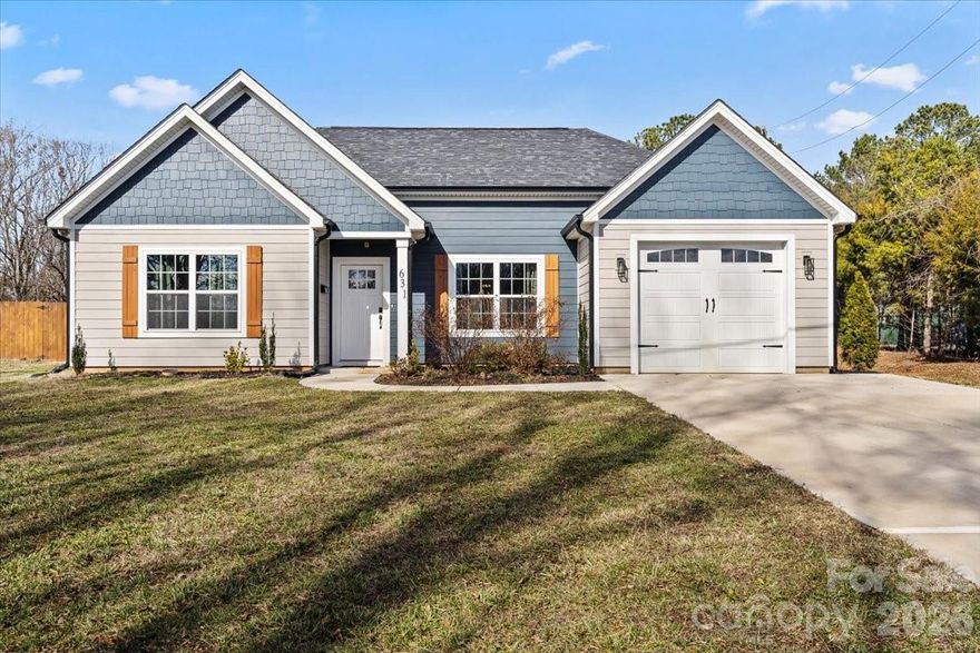 Get ready to fall in love! This one-story home offers 3 bedrooms and 2 full baths with 1,382 sq ft on a spacious .62-acre lot blends comfort, style, and a connection to nature! The open-concept floor plan features wide plank flooring, recessed lighting and a modern kitchen with white shaker cabinets, quartz countertops and stainless steel appliances. Large kit island provides additional prep space and seating. Dining area overlooks the fully fenced backyard, creating an easy flow for everyday living. This home is filled with natural light and designed for effortless entertaining—whether you're hosting lively gatherings or enjoying a cozy night in. The primary en-suite is a true showstopper, featuring a tray ceiling, spacious custom walk-in closet, and a private bath that feels like your own personal retreat. Secondary bedrooms and bath offer endless possibilities for family/guests, a home office or creative space. Step outside to your expansive backyard with storage shed, where there’s room to play, garden, entertain, or simply unwind while taking in the peaceful sounds of nature all around you. And the location? Minutes from the charm, excitement and events of downtown Kings Mountain, with the new Casino, shops, restaurants and beautiful local vineyard for weekend tastings and scenic escapes. Outdoor enthusiasts will appreciate close proximity to Crowders Mountain State Park with hiking and scenic overlooks, as well as the KM Gateway Trail for walking and biking. Patriot Park provides playgrounds, green space and community events throughout the year. Kings Mountain Country Club is also nearby for golf and social activities. Quick access to major roadways makes commuting to Gastonia, Shelby or the greater Charlotte area simple, while still enjoying the space and privacy of a generous country-style homesite. This home is the total package—bright, welcoming, and full of energy, with the perfect balance of convenience and tranquility. This nearly new construction offers modern style, efficient design and the benefit of recent construction without the wait of building. Don't miss it!