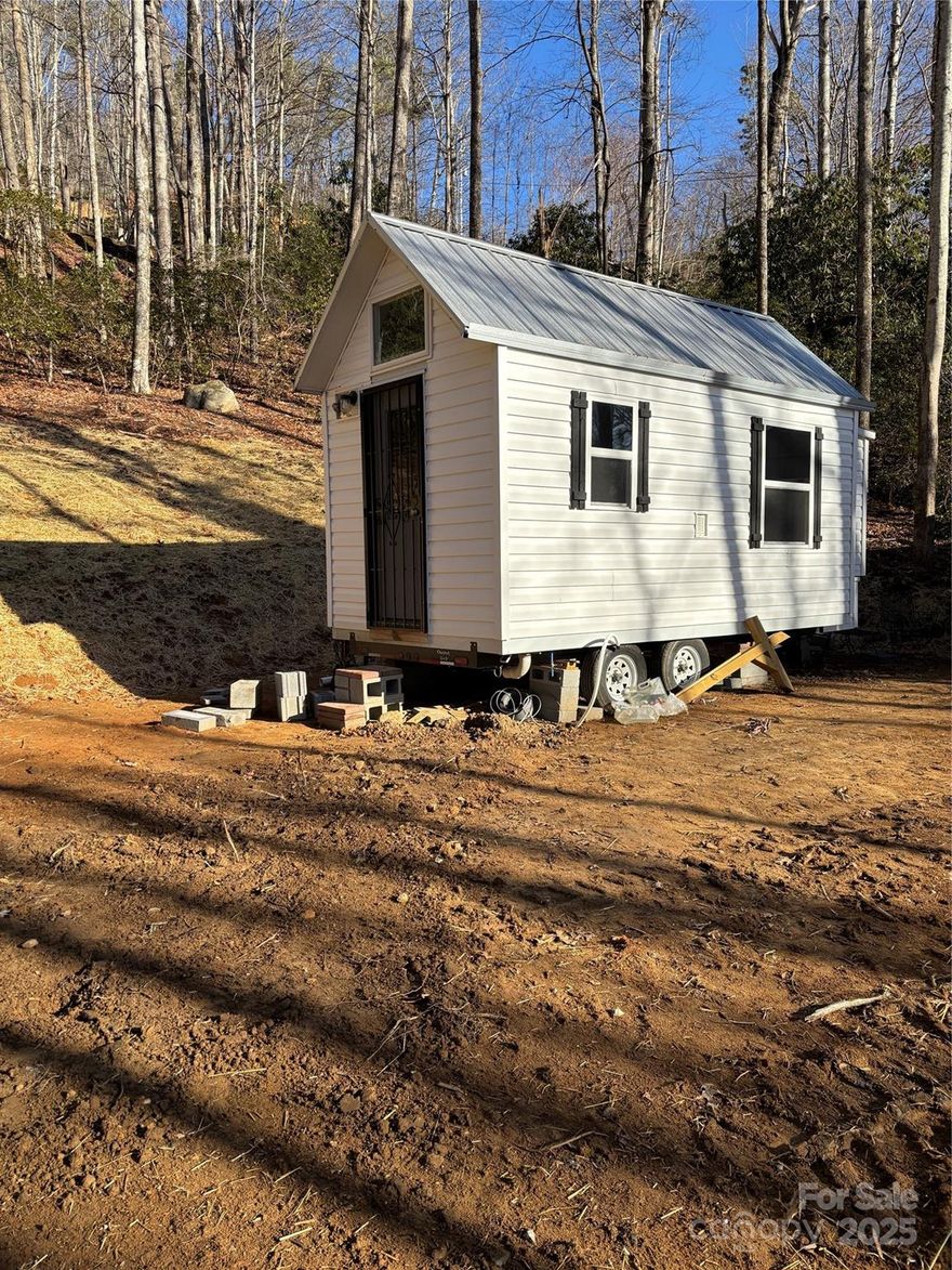 Unique Rare find! NO restrictions! Currently includes a brand new tiny house. (seller paid $45K for house, keep it or sell it and build your dream home!) Brand new well with filter system. Brand new septic being installed 1/15. Grading and building lot completed. Currently has one tiny home but a second can be added with current septic. Room to add several more tiny homes if desired. This is a huge property with only a small portion being used. May easily be divided into several lots. Bring your RV or park model, build your dream cabin or home. Privacy galore and located on paved Sheepback Mountain Rd. Base of driveway is split into two allowing a Buyer to have mutiple building sites.