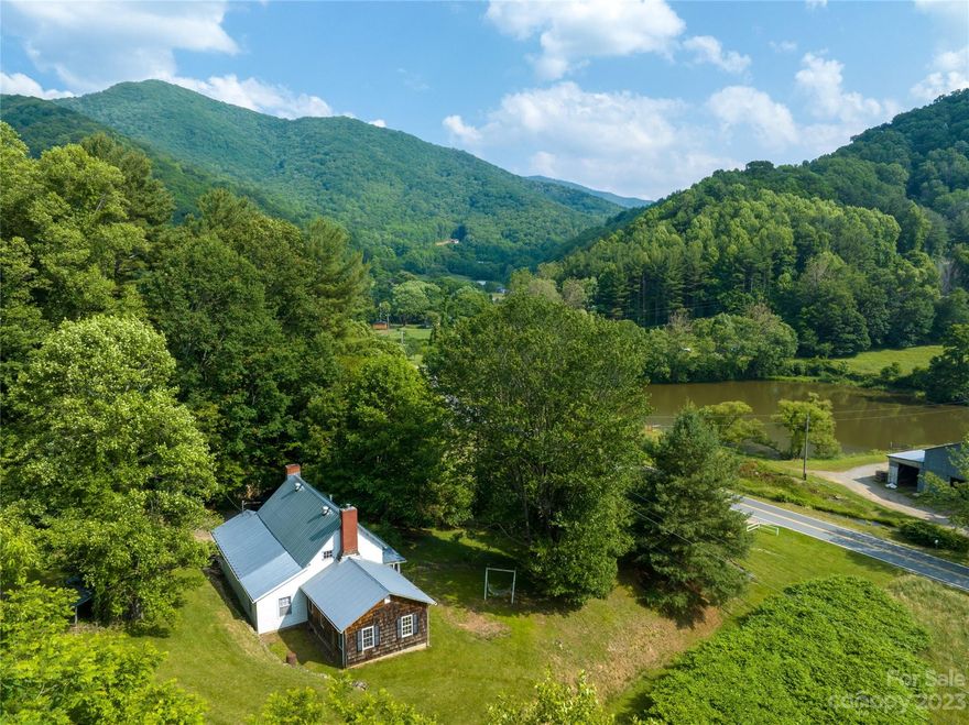 Your dream of an authentic Appalachian homestead awaits! With the perfect blend of town & country, this property is situated in the beautiful & pastoral Bolens Creek valley but only 5 mins from the cute & quaint Burnsville downtown & 3 mins from the Black Mountain Crest trailhead. The lovely old farmhouse exudes a warm charm, history, & character whether you're on the rocking chair-ready front porch gazing out at the epic mountain & valley views or exploring the 13+ acres of lush woods complete with wildflowers and bubbling springs. With 3 bedrooms and 2.5 baths spanning 2000+ SF, this home awaits your vision to breathe new life into its next chapter! The home is being sold as-is through a family estate along with the adjacent 12.76-acre tract.  A grassy roadbed leads up to a level & cleared area that could potentially serve as another building site. This dream property even includes creek frontage to enjoy summertime wading, fishing, and relaxation. Go see it now before it's gone!