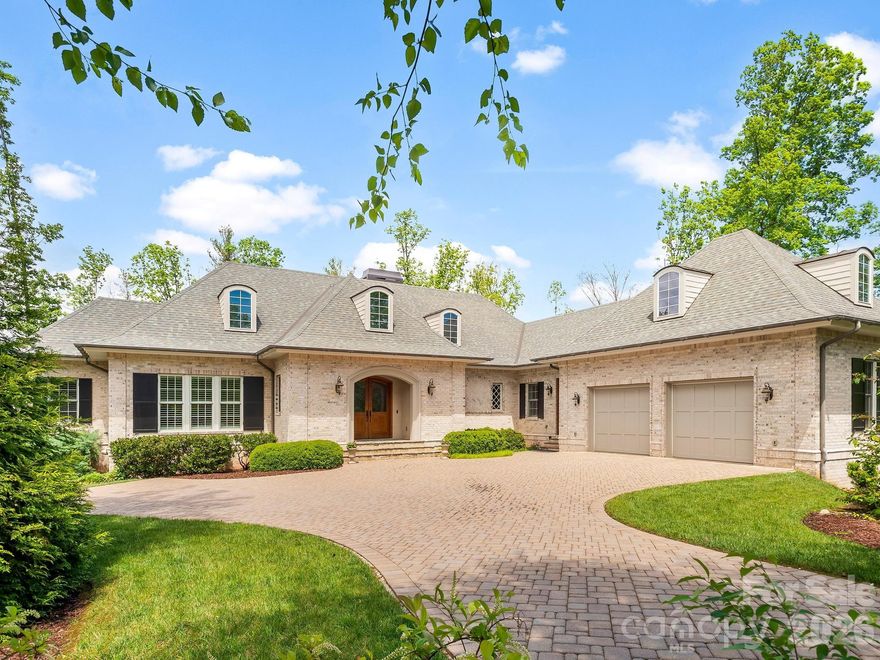 Welcome to this French country inspired home in the heart of south Asheville! With its casual elegance and inviting appeal, it is ideal for those seeking a home that is both comfortable and stylish. Nestled at the end of a quiet cul-de-sac, the home features authentic brick construction and flagstone entryway. Inside, a spacious kitchen, dining and sitting area emphasize comfort and functionality. The double-sided fireplace provides warmth and ambiance. Three sets of French doors open onto a spacious, fully screened porch, enhanced by ceiling fans and skylights. The primary bedroom boasts a gas fireplace and relaxing ensuite bathroom with spacious walk-in shower, soaking tub and double vanities. A private office is conveniently situated on the main level, while an additional guest suite and two bedrooms on the lower level offer flexible options for living space. The walk-out patio opens to a private backyard next to community greenspace. Modern heating systems, high-quality insulation, and a generator ensure comfort and peace of mind year-round. For added convenience, the home includes surround sound, two dishwashers, two washers, two dryers, energy-efficient tankless hot water heaters and a whole-house water filtration system. Plus, a large unfinished storage area can be finished into a home gym, theatre room or extended living space. This blend of practical amenities, modern comforts, and elegant design creates a refined yet comfortable retreat in a truly beautiful setting.