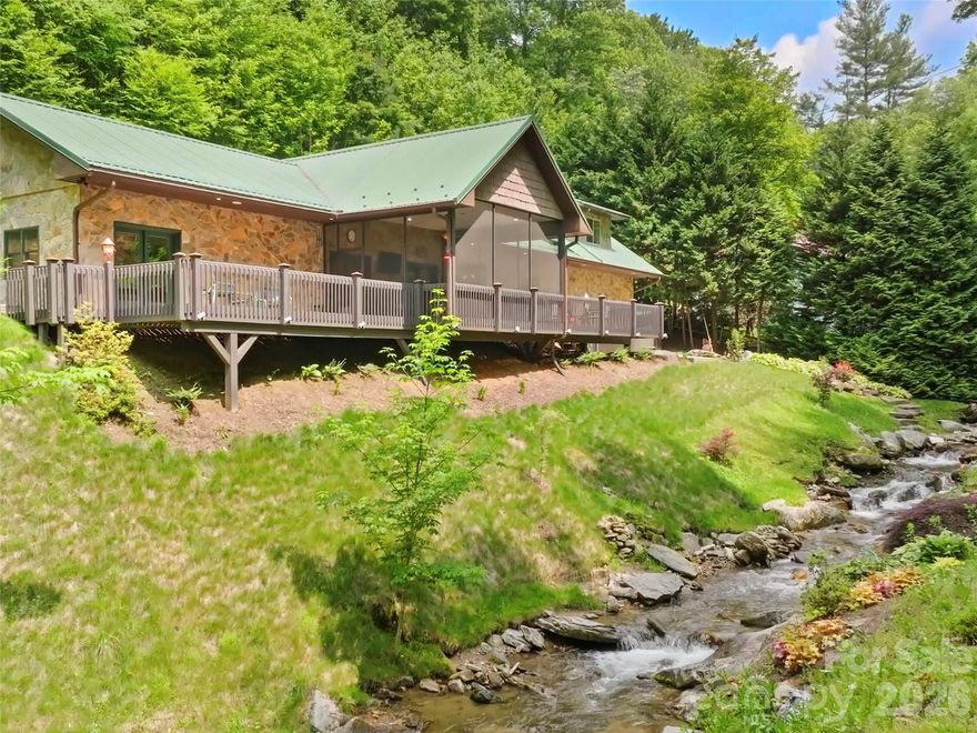 Set along 240 feet of tranquil creek frontage and just three miles from Cataloochee with long range Winter mountain views, this beautifully crafted, pre-inspected ICF (Insulated Concrete Form) home offers exceptional energy efficiency, durability, and a truly serene mountain retreat. The residence features a striking living room with a vaulted ceiling, bathed in natural light thanks to strategically placed sun tunnels, and anchored by a beautiful stone, gas-log fireplace. The functional and stylish chef’s kitchen is perfectly equipped for cooking and entertaining, boasting elegant cherry cabinets, a double oven, a gas cooktop with a vented hood, and both a peninsula and an island. Retreat to the luxurious creek-view primary suite, which includes a spa-like bath and a custom walk-in closet with thoughtful built-in organization. Adding ultimate flexibility is a private guest suite over the garage, which comes complete with its own separate entrance, a full bath, and individually zoned heating and AC, making it ideal for long-term visitors or a separate living space. Outdoor enjoyment is maximized with low-stress, beautifully maintained landscaping accessible from 2 sunny decks, a relaxing screened porch, or the dedicated hot tub patio. The home offers unmatched peace of mind with a Liquid Cooled Generator for uninterrupted power, a shared well, and a 2-bed septic system, all underscored by recent professional interior paint applied in 2023 and the inherent strength of the ICF construction. Comes Pre-Inspected. Home had no flooding/damage during Hurricane Helene.  Just minutes away from the heart of Maggie Valley's restaurants, shopping and entertainment.  Located only a few miles to Cataloochee Ranch and Cataloochee Ski Resort.