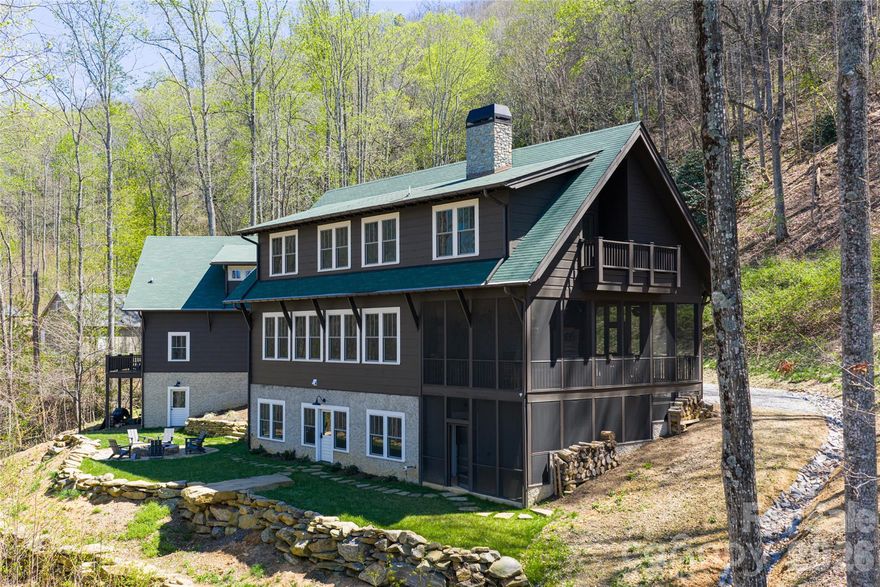 Mountain luxury at its finest, where timeless architecture and thoughtful design come together in every detail. Seamless indoor-outdoor living creates an exceptional setting for both everyday life and effortless entertaining. High ceilings, expansive windows, and 8 foot doors and 10 foot ceilings on the main level enhance the sense of space and light, while shiplap accents add warmth and classic mountain character. A high efficiency wood-burning fireplace anchors the main living area, offering both comfort and charm.

The screened-in porch extends the living space outdoors and features a wood-burning fireplace with a gas starter and infrared ceiling heaters —perfect for year-round enjoyment in the mountain air. 

The main residence offers 4 bedrooms and 3.5 baths, complemented by a private basement apartment with its own entrance, full kitchen, living area, bedroom, and bath—ideal for guests or extended stays. An additional flex space includes a workout room and an unfinished covered outdoor area already plumbed for a future hot tub and sauna.

A true architectural highlight, the staircase—crafted from reclaimed wood from a historic tobacco factory—adds a striking and meaningful design element.

The multi-level garage structure is exceptional, featuring a lower-level workshop with oversized garage door, main-level garage, and an upper-level office with deck and large pull-up door. The top level, with its own entrance, is currently used as an Airbnb-style suite, offering a spacious living area, sleeping space, and kitchenette.

Outdoors, a large firepit invites gathering under the stars, surrounded by a wooded setting with multiple cleared vantage points showcasing stunning, year-round views.

A rare blend of luxury, versatility, and mountain lifestyle—this property is truly one of a kind.