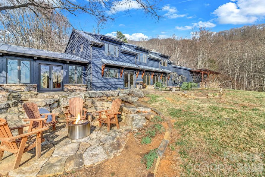 A gorgeous mountain estate on a private and stunning 12.72 acre parcel with stunning Asheville mountain views. These spectacular grounds feature a babbling brook, lovely pasture area and hiking trails to the blue-ridge parkway. This elegant property contains a beautifully renovated separate guesthouse. Located not far from vibrant downtown Asheville, award-winning restaurants, the blue-ridge parkway and musical hot-spots. This home is brimming with features such as natural mineral plasters, custom designs and cabinetry. The estate home is the very essence of understated elegance. Entertain family and friends in the great room highlighted by walls of windows displaying stunning long range mountain views. Fantastic Viking appliances, double oven, and handsome heart wood beams and accents throughout. Relax by one of 2 fireplaces, or retreat to your main bedroom w/ sitting room, private access to the lovely patio, and gracious en-suite bath. Separate apartment just perfect for guests/rental/in-law suite! This is a rare find if you desire privacy, year-round stunning views, easy access and a fantastic walk-able parcel. The outdoor pictures were taken in a previous season to capture the summer landscaping.