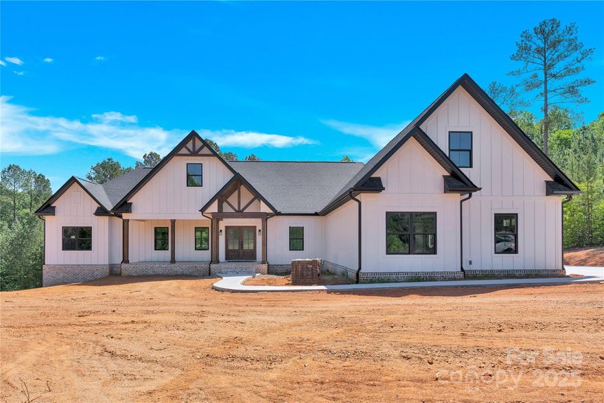 Stunning custom home in THE RESERVE in River Oaks Landings - a gated community w/ private lake access on ~2 acres! Exposed cedar beams on covered front porch set the tone for rustic-modern appeal. Inside find ceilings finished w/ the same beautiful cedar. Spacious 3 bedrooms, 2 baths on MAIN, 2nd level bonus w/552 sf, WALK OUT basement w/ 663 sf workshop and/or 4th garage,+ unfinished basement w/ plumbing - bath, kitchenette? Gourmet kitchen w/ lg island, hidden walk-in pantry, leathered granite, gas stovetop! Elegant Primary: Vaulted ceilings, spa-like en-suite  w/ freestanding tub, makeup vanity, walk-in closet, linen closet. Premium Flooring, Tauleto Bianco Stone Look Tile, Energy Efficiency & Smart Home Features: Tankless hot water heater, 400-amp electrical panel w/ expansion room, and EV-ready 3-car garage wiring. Laundry w/ utility sink. Trex Deck, cocktail railings, gas hookups for a future FP, grill. Lake access is perfect for boating, fishing, kayaking, lakeside relaxation.