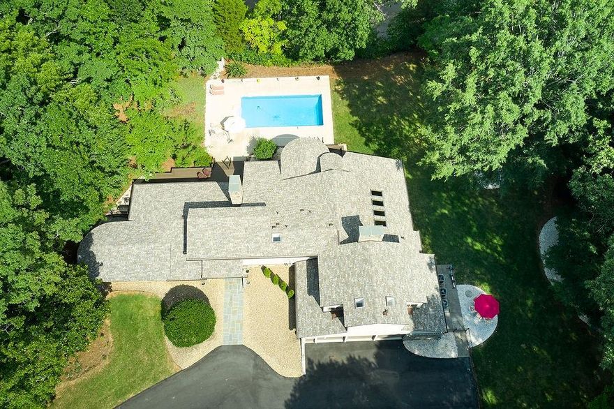 See Updated Photos of NEW ROOF and DECORATIVE FOUNTAIN! PRICED BELOW APPRAISAL.Contemporary architecture inspired by themes of Frank Lloyd Wright. Walls of windows, skylights, and large expanses of glass blend the outdoor and inner spaces in a harmonious, sophisticated, minimalist style. Brazilian cherry hardwood floors, cedar wood ceilings, stone fireplaces, blue stone entry, along with beautiful views of two lakes create a Feng shui environment. An inground pool & private dock on a lake lot makes an ideal place for relaxing or entertaining. A major renovation includes a new rotunda outdoor dining patio, kitchen granite, addition of Italian and Spanish indoor lighting, and a floating stair case up to a sky bridge.The primary bath is spa-like and joins with dual WICs. 3 bay garage lined in cedar with a workshop. Truly exquisite and unique in a private gated neighborhood with picnic shelter in common area.