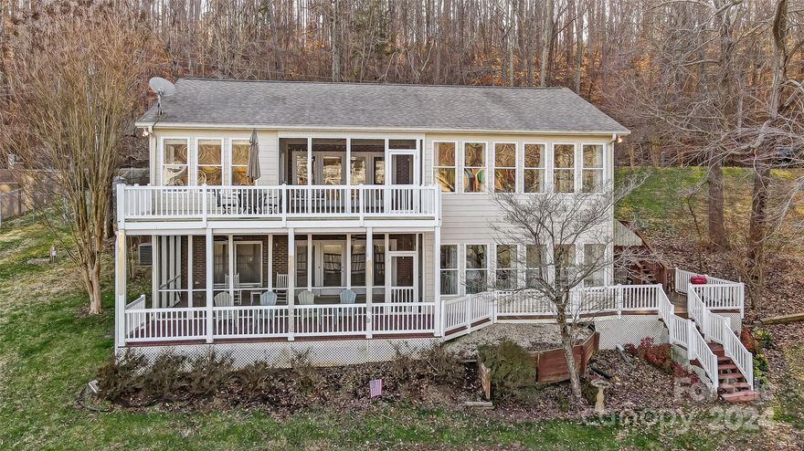 This waterfront gem is sure to "WOW" you with amazing views of Lake Wylie! The 2 screened porches, multiple decks, spacious yard, & floating dock are perfect spots for outdoor entertaining or to take in the views. Tax record shows age of home as 1945, however, it was rebuilt in 1996.  This home has it all – beautiful floors, crown molding, open floor plan, & tons of windows. You’ll love the kitchen featuring SS appliances, large island, & granite counters opening to the great room, sitting room, & dining area w/ fireplace. Main level primary suite provides walk-in closet, sitting area, updated bath, & access to screened porch. Lower level is perfect for 2nd living quarters featuring sunroom, large rec room w/ fireplace, 2nd kitchen, 2nd laundry, storage, & bedroom w/ full bath. Fenced yard w/ gated entry.  Located on a wide cove opening to the main channel, the best of both worlds. Get away from it all, yet live close to River District, shopping, dining, Uptown Charlotte, & airport.