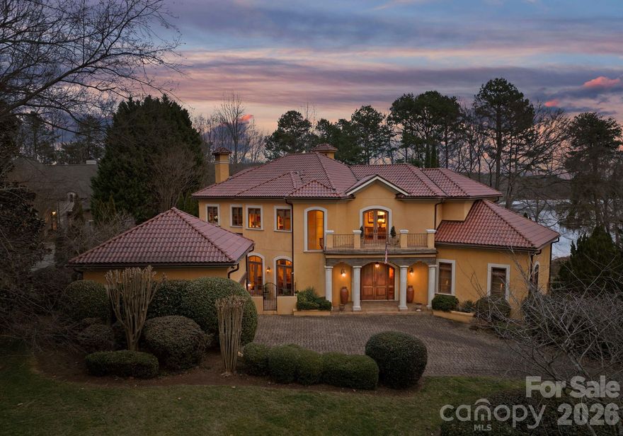 Gracefully positioned along a wide, open stretch of Lake Norman within the prestigious community of The Point, this European-inspired waterfront estate blends timeless architecture with elevated lakefront living. Warm stucco exteriors, arched windows, and rich wood detailing create a striking first impression, while inside, exposed beams, stone fireplaces, and handcrafted cabinetry reflect old-world craftsmanship rarely found today. Expansive windows and French doors frame sweeping water views and seamlessly connect the interior to outdoor terraces. The primary suite is thoughtfully located on the main level, offering a private retreat complete with a spa-style bath featuring dual vanities, soaking tub, and walk-in shower. Upstairs, generously sized secondary bedrooms are complemented by a dedicated office, craft room, and spacious bonus area — providing exceptional flexibility for modern living. The walkout lower level transforms into a lifestyle wing with a fully equipped exercise room, substantial workshop, and abundant storage. Outside, a private dock extends your living experience onto the water, perfectly positioned along a serene yet expansive cove with long-range views ideal for boating, paddle mornings, and sunset cruises. A rare opportunity to own a distinctive waterfront residence in one of Lake Norman’s most sought-after golf and waterfront communities.