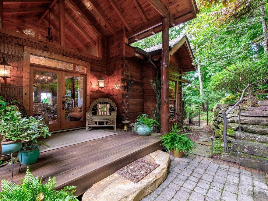 This 3 bed, 4 bath home offers a perfect blend of rustic charm and modern elegance. The post and beam construction and vaulted ceilings create a modern loft feel, while rustic details evoke mountain homes of the past. The open kitchen and living room foster a social atmosphere and extend to an expansive deck with views of the Blue Ridge Parkway. Designed for one-level living, the main floor includes all necessities. The primary suite features 20-foot ceilings, huge transom windows, and dual en-suite bathrooms. An office, guest bedroom, and bath complete this level. The lower level is ideal for guests or hobbies, with a family room, an art studio with floor-to-ceiling windows, a screened porch, and an additional deck leading to a grassy yard and garden area. Outside, the home is surrounded by enchanting gardens, extensive hardscape, stone pathways, a water feature, and raised garden beds. This private oasis offers breathtaking views and a unique living experience.