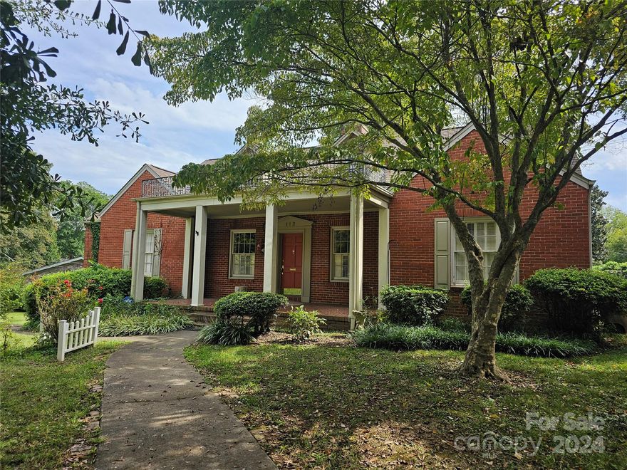 This 3 bedroom, 2 bathroom home has lush landscaping on an oversized lot.  You are greeted by large white columns and a lovely front porch.  Enter the home and you are instantly met by the charming fireplace with decorative wood flower paneling over the mantle.  Hardwoods are featured throughout much of the home.  The kitchen features an oversized pantry and convenient access to the laundry room.  A cozy breakfast nook comes with built ins and a stained glass lighting.  The family room also features built ins, a second fireplace and plenty of natural lighting.  Guest bathroom features a swan faucet and lovely gold colored chandelier.  The primary bedroom has its own ensuite bathroom with modern lighting and vanity.  Windows throughout the home feature plantation shutters and glass doorknobs are found on select doors.  Cedar closets and in closet automatic lighting can be found.  Enter the basement and you have plenty of storage opportunity.
