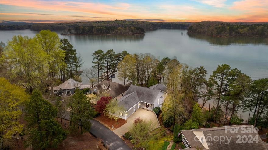 Owner financing now available! Delight in the charm of this lakefront treasure! Water views from every major room! Spacious design on 2 levels, 10 ft ceilings, 3 BR suites with their own private bathroom & walk-in closets, & oversized 3 car garage w/epoxy floor & ceiling fans! Main Level tinted windows protect luxury vinyl floors & furniture. Great Room w/stone fireplace and built-in speakers! Open kitchen & dining area w/ GE Profile appliances, granite counters, soft close cabinetry, & 2023 Samsung refrigerator. Sunroom grants year-round lake views. Owner's suite boasts ensuite bath & dressing room with built-ins, walk-in closet, soft close drawers, tiled shower w/ 2 heads, granite counters, double sinks & seated vanity. Wide stairs to lower level, with immediate lake views through French doors to lower level covered porch. 2 water view suites & office w/ built ins. New walkway to the COVERED dock w/lift, & new steps to private beach! Furniture/furnishings are negotiable!