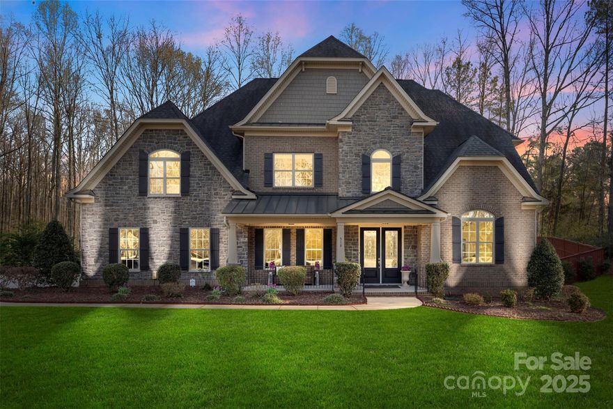 Welcome home to timeless elegance and modern comfort in this peaceful community with walking trails. Double mahogany and glass doors lead to a stunning two-story foyer, flanked by a formal dining room and spacious office. The great room features custom built-ins, a coffered ceiling, and a stone gas fireplace. A chef’s kitchen showcases granite countertops, painted linen cabinetry, a custom island, walk-in pantry, and butler’s pantry with beverage center. The main-level primary suite offers a luxurious bath, oversized walk-in closet, and walkout access to a serene three-season room. Upstairs you’ll find three generous bedrooms, multiple baths, and two versatile bonus rooms. Enjoy plantation blinds, updated flooring (2020), privacy fencing, and both front and back covered porches. The oversized 3-car garage includes custom storage, and the mudroom and laundry are loaded with cabinetry.